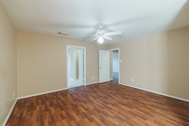 empty room featuring ceiling fan, dark hardwood / wood-style floors, and a textured ceiling