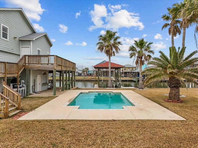 view of swimming pool with a deck with water view, a patio, and a lawn