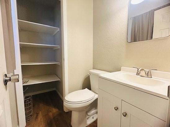 bathroom featuring vanity, wood-type flooring, and toilet