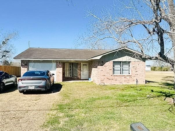 ranch-style home with a garage and a front yard