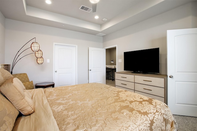 carpeted bedroom with a raised ceiling