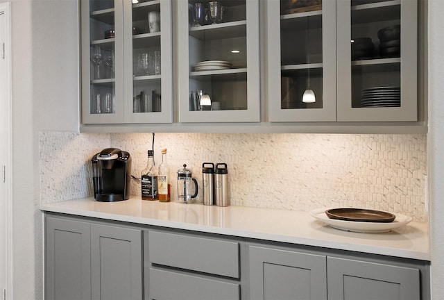 bar with gray cabinets and decorative backsplash