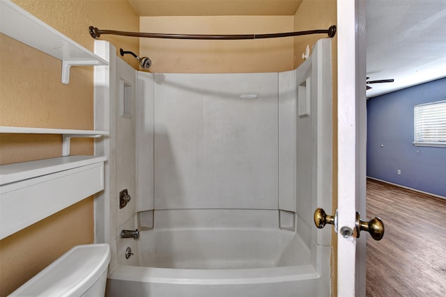 bathroom featuring shower / bathtub combination, a textured ceiling, and toilet