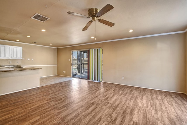 unfurnished living room featuring ornamental molding, ceiling fan, and light wood-type flooring