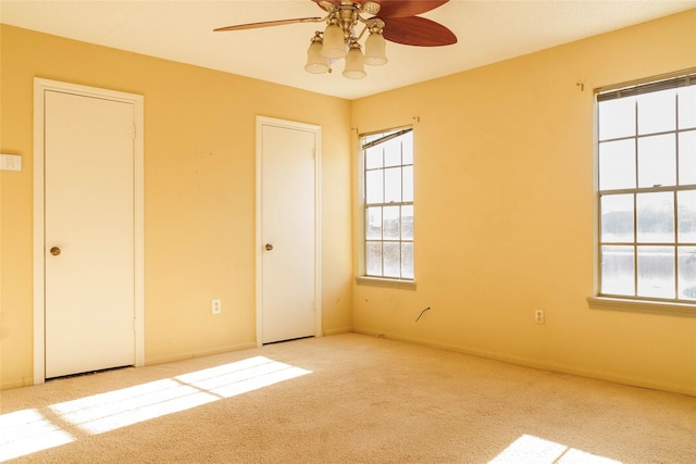 unfurnished room featuring light carpet and ceiling fan