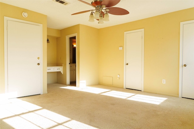 unfurnished bedroom with light colored carpet and ceiling fan