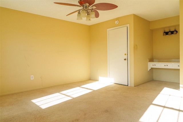 carpeted empty room featuring ceiling fan