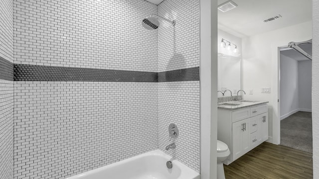 full bathroom with vanity, toilet, tiled shower / bath combo, and wood-type flooring