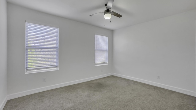 carpeted spare room with a wealth of natural light and ceiling fan