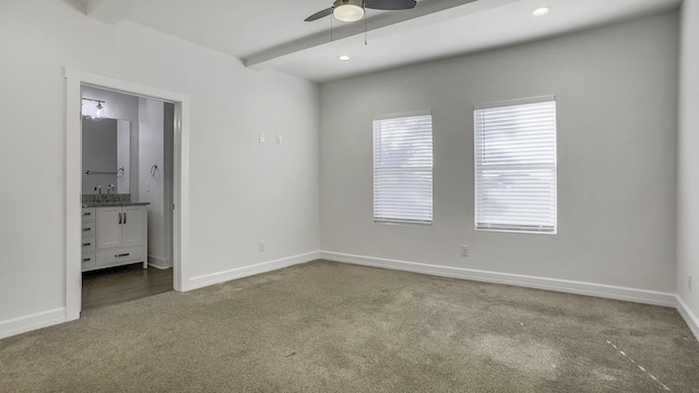 carpeted spare room featuring sink, beam ceiling, and ceiling fan