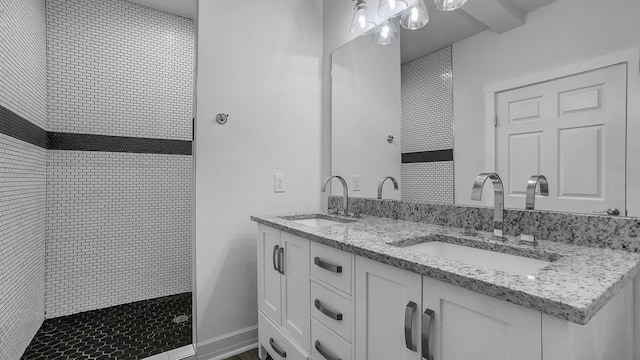 bathroom with vanity and a tile shower