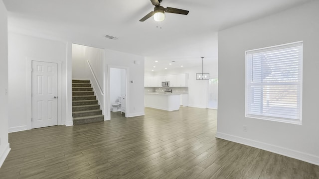 unfurnished living room featuring dark hardwood / wood-style flooring and ceiling fan