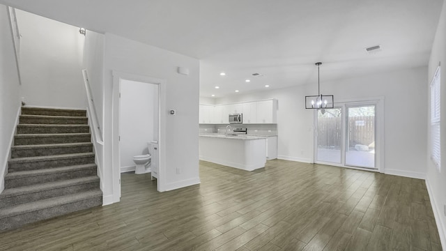 unfurnished living room featuring sink and a notable chandelier