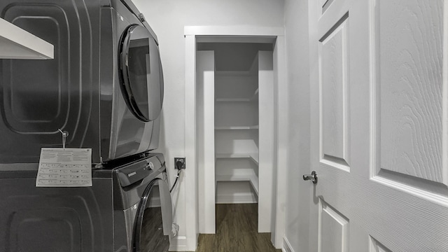 washroom with dark wood-type flooring and stacked washer and clothes dryer