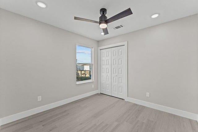 unfurnished bedroom with light hardwood / wood-style flooring, ceiling fan, and a closet