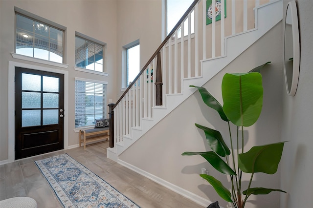 foyer entrance featuring a high ceiling and light wood-type flooring