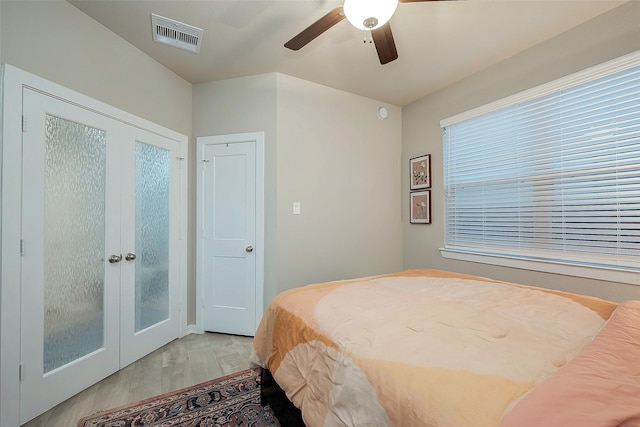 bedroom with french doors, ceiling fan, and light hardwood / wood-style floors