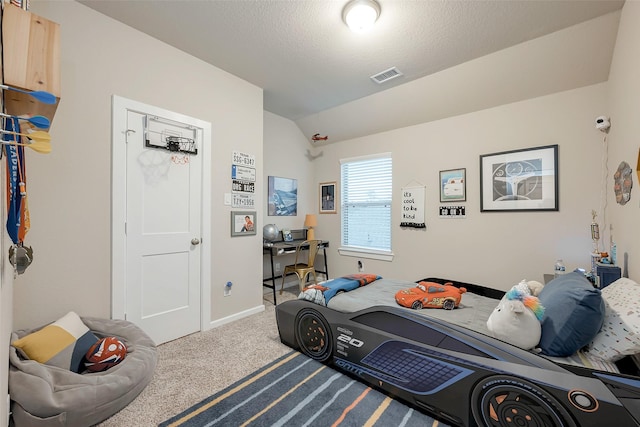 bedroom with carpet floors, a textured ceiling, and vaulted ceiling