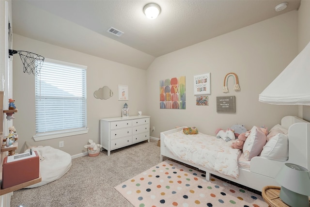 bedroom with vaulted ceiling, carpet, and a textured ceiling