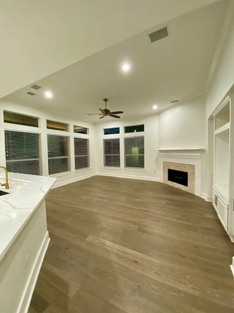 unfurnished living room featuring dark wood-type flooring and ceiling fan