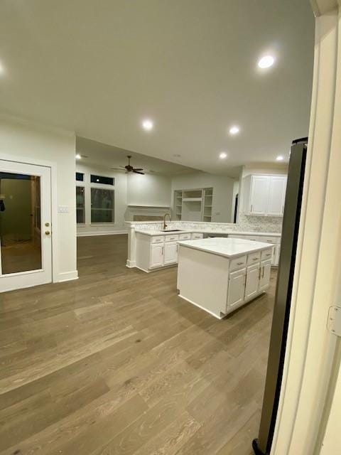 kitchen featuring white cabinetry, a center island, stainless steel fridge, and light hardwood / wood-style floors