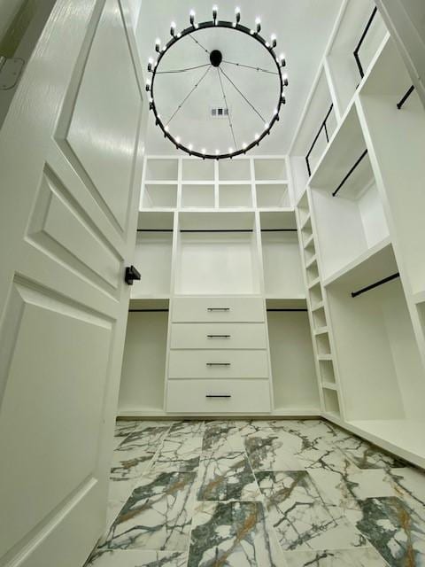 spacious closet with an inviting chandelier