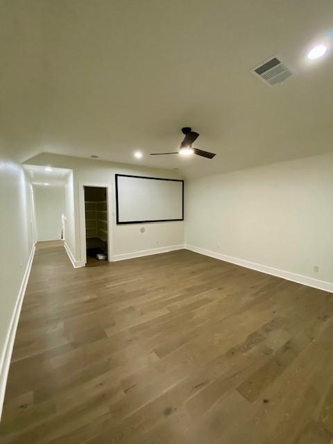 home theater room featuring hardwood / wood-style flooring and ceiling fan