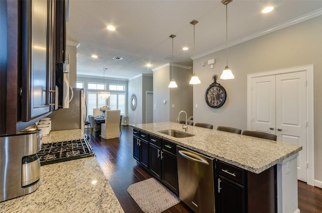 kitchen with sink, dishwasher, a kitchen island with sink, light stone countertops, and decorative light fixtures