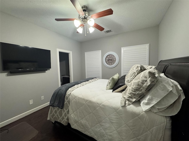 bedroom featuring ceiling fan, dark hardwood / wood-style floors, and a textured ceiling