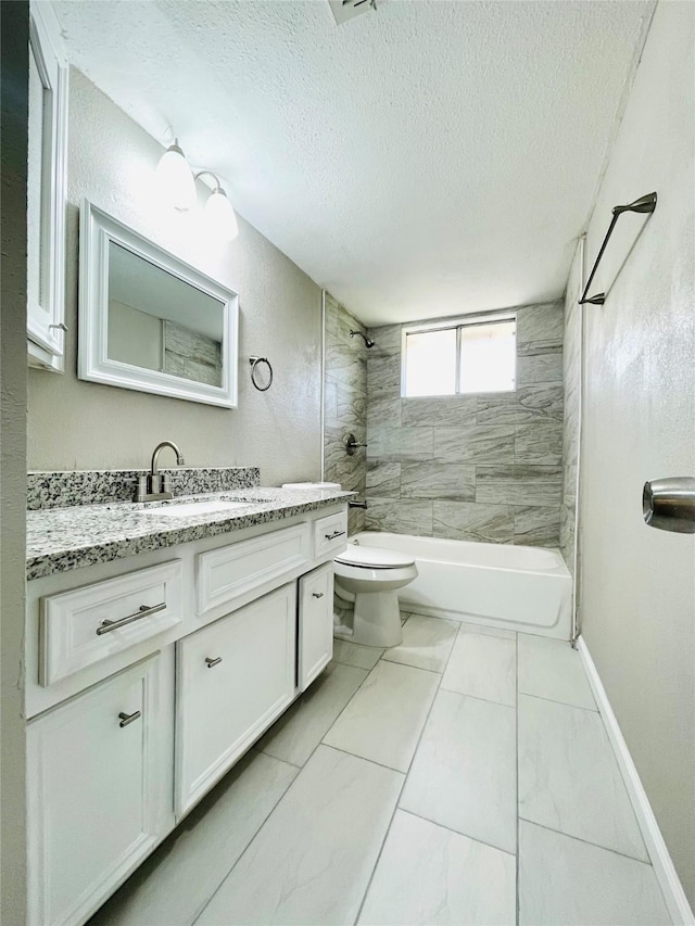 full bathroom featuring vanity, toilet, a textured ceiling, and tiled shower / bath