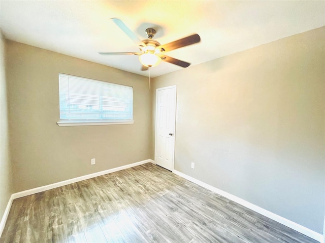 spare room with ceiling fan and light wood-type flooring