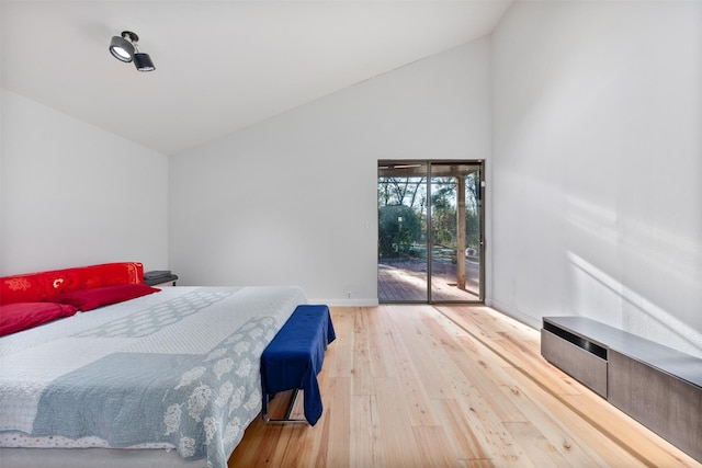 bedroom with lofted ceiling, access to exterior, and wood-type flooring