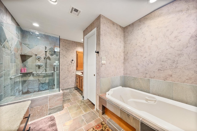 bathroom with vanity, independent shower and bath, and tile walls