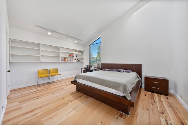 bedroom featuring lofted ceiling and light hardwood / wood-style flooring