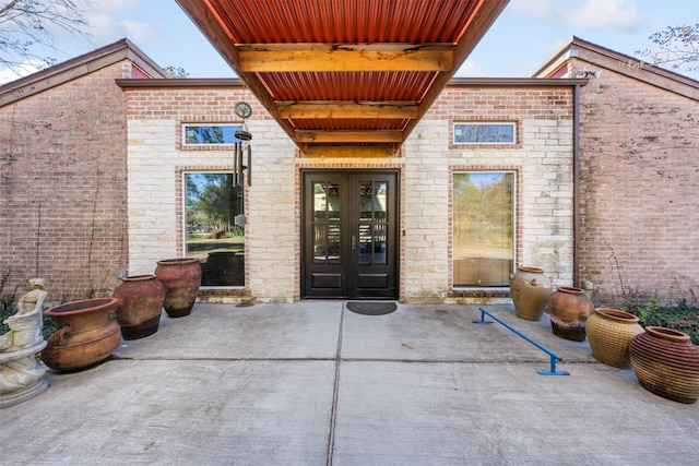 view of exterior entry with french doors and a patio area