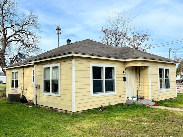 rear view of house featuring a yard and central AC