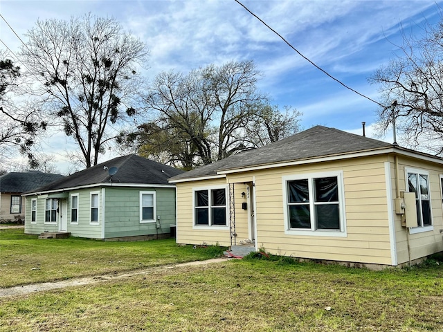 rear view of property featuring a yard