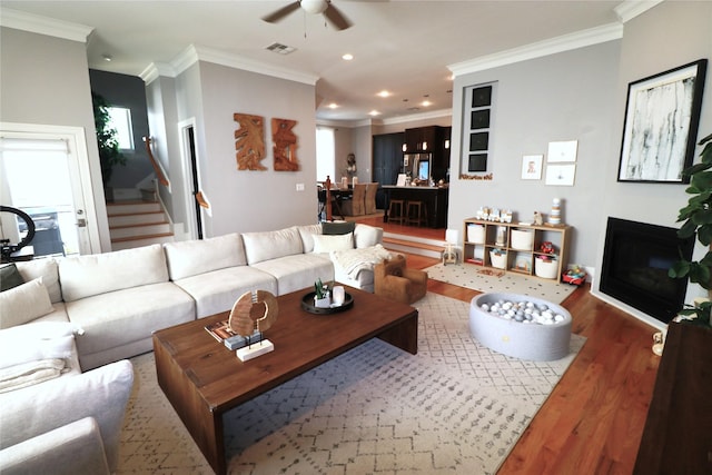 living room featuring ornamental molding, dark hardwood / wood-style floors, and ceiling fan