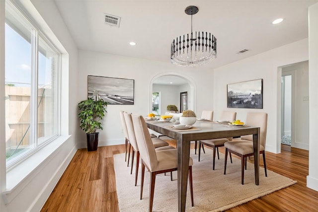 dining room with light hardwood / wood-style flooring and a chandelier