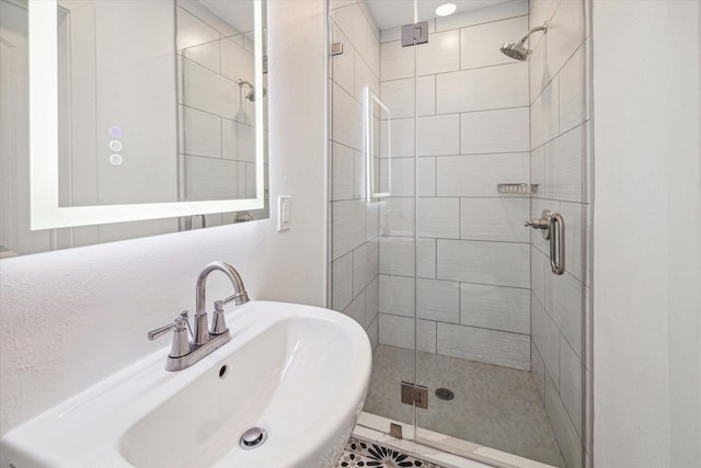 bathroom featuring tile patterned flooring, a shower with shower door, and sink