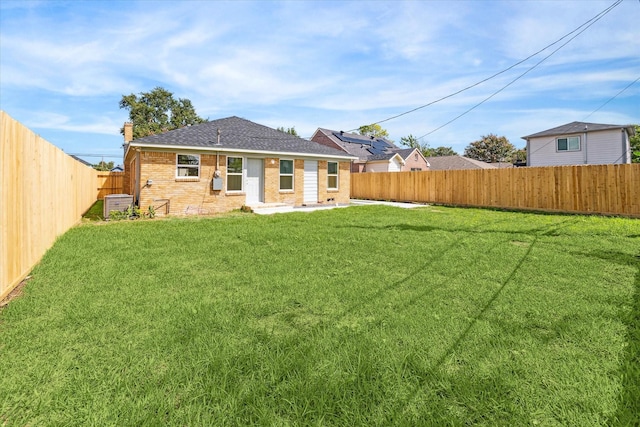 back of house with a lawn