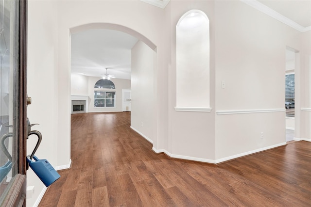 corridor with ornamental molding and hardwood / wood-style floors