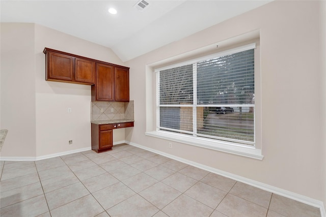 kitchen featuring vaulted ceiling, decorative backsplash, and light tile patterned floors