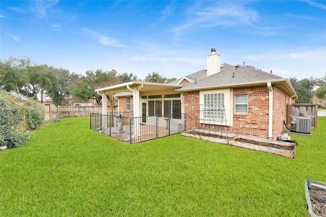 back of property with a yard, a patio, and central air condition unit