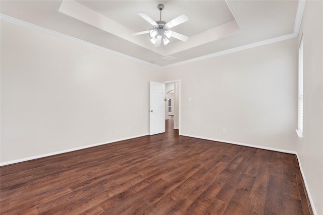 unfurnished room featuring a tray ceiling, ornamental molding, dark hardwood / wood-style floors, and ceiling fan