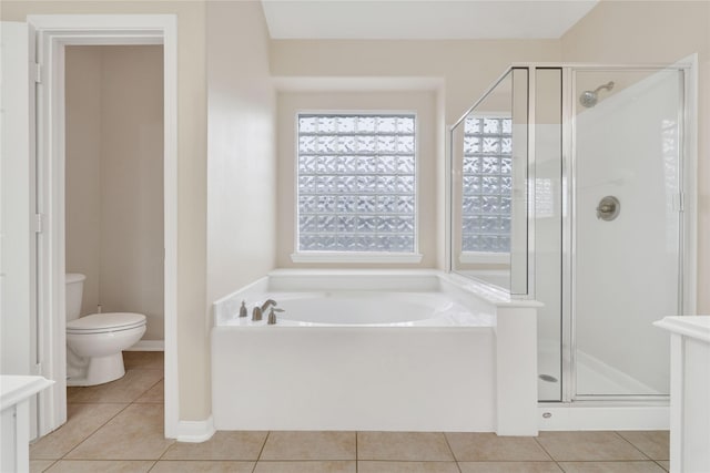 bathroom featuring a healthy amount of sunlight, tile patterned flooring, plus walk in shower, and toilet