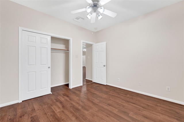 unfurnished bedroom featuring dark wood-type flooring, ceiling fan, and a closet