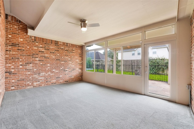 unfurnished sunroom featuring ceiling fan