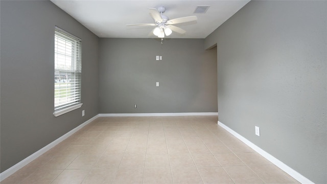 spare room featuring light tile patterned floors, plenty of natural light, and ceiling fan