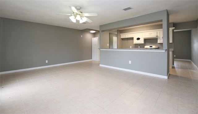 unfurnished living room featuring ceiling fan, sink, and light tile patterned floors